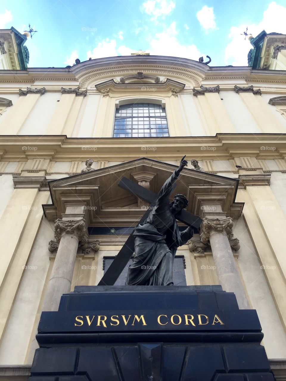 A statue of a Jesus Christ with a crucifix in front of a church