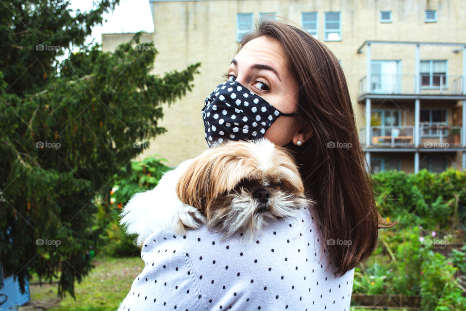 Girl wearing a mask and hugging her dog