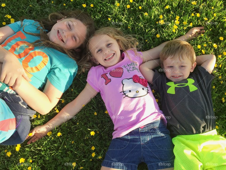 My three beautiful children lounging in a field of buttercups. 