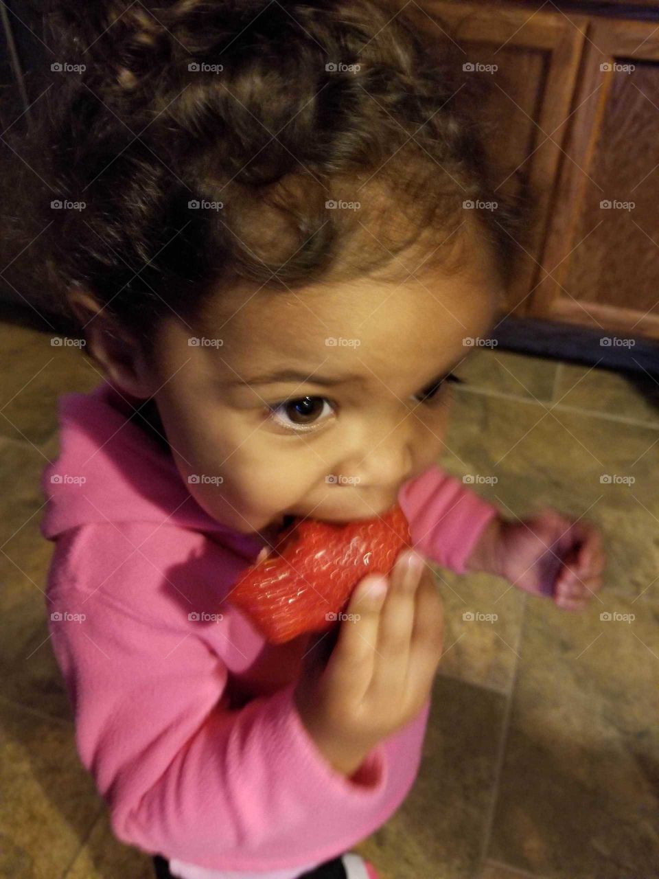 wide open eyes as she got handed a huge strawberry to eat instead of cut up pieces, delighted eyes dance with excitement, strawberries are the best