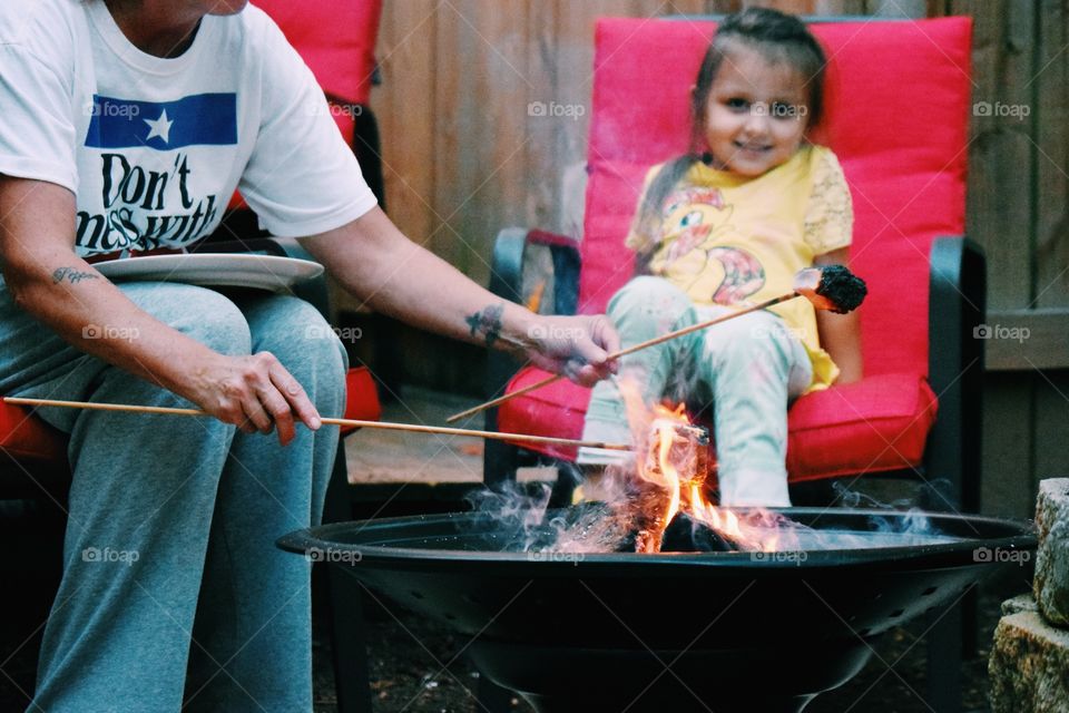 Man grilling meat on bonfire