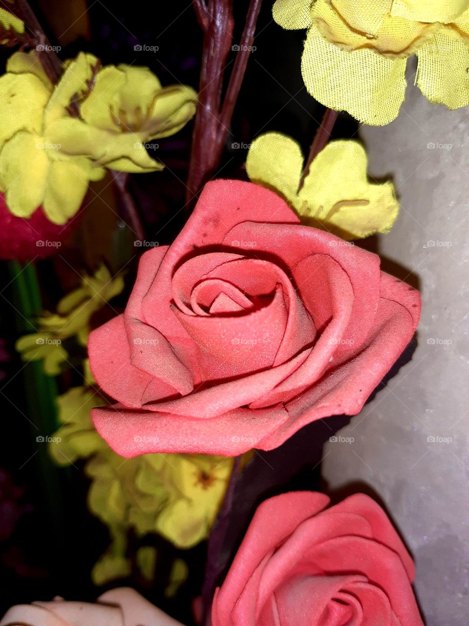 On January 1, 2025, in Casablanca, a pink rose sits at the center, surrounded by vibrant yellow roses. The contrasting colors create a stunning, balanced display