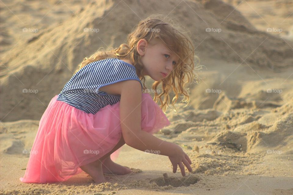 Girl playing in sand at beach