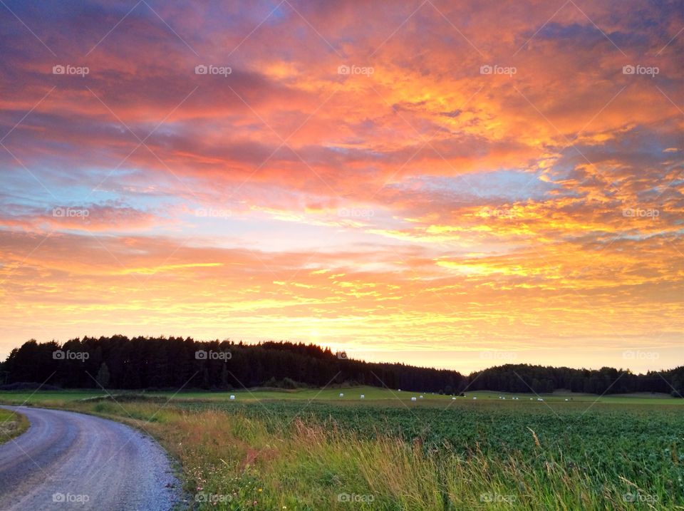 Dramatic sky against grass and road