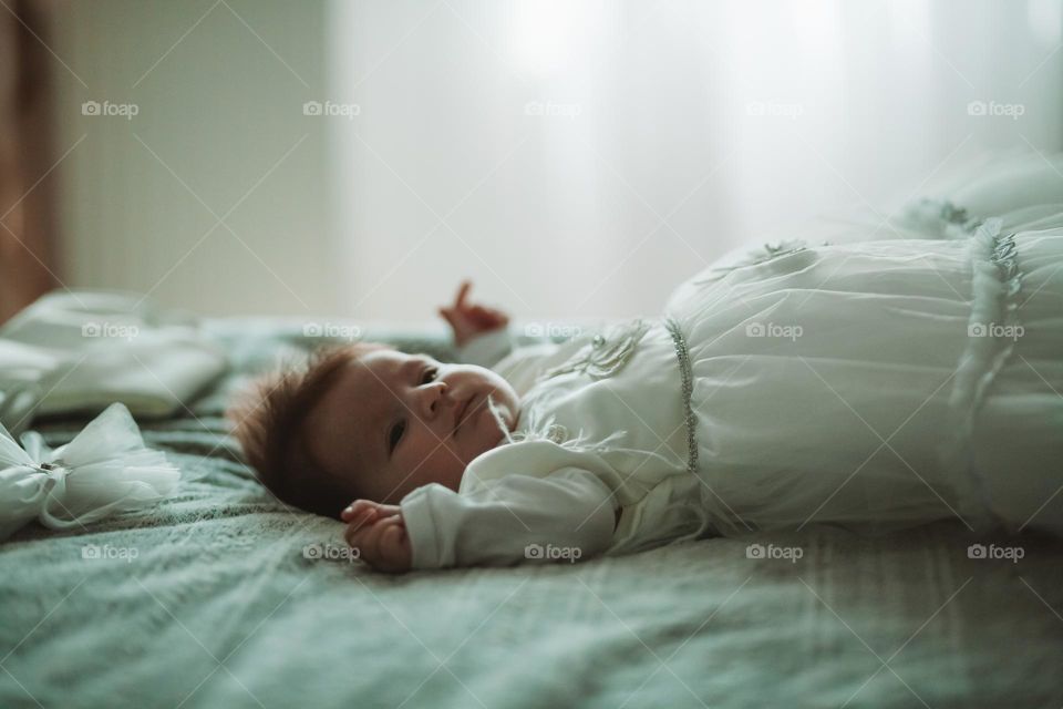 baby girl sitting on the bed