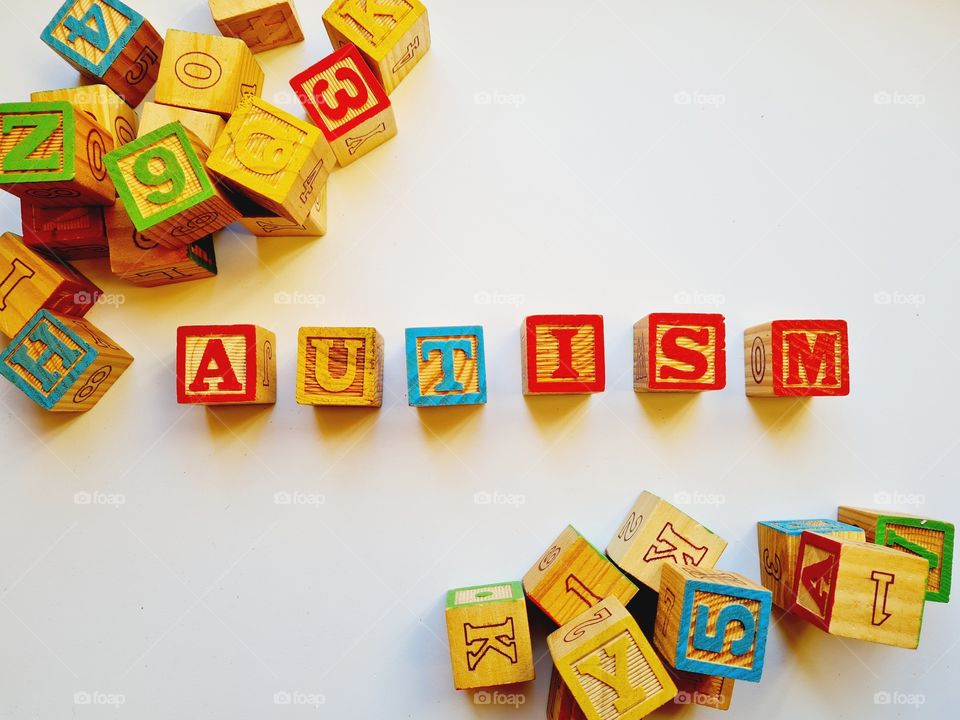 written autism with wooden cubes