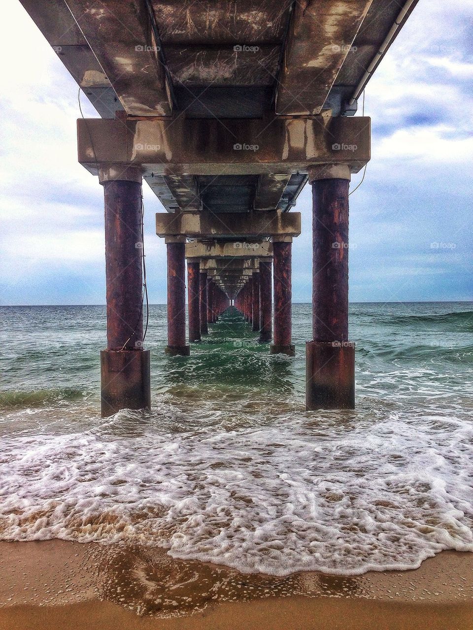 Ocean waves under the piers pillars