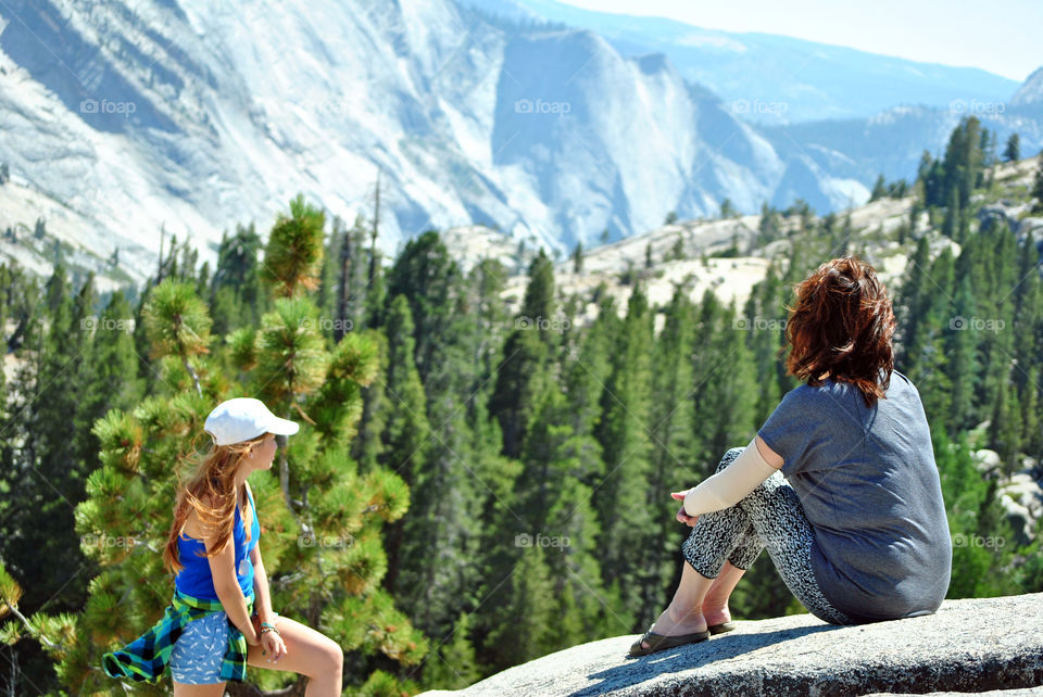 Two women looking at the the beautiful mountain, canyon view, on top a rocky mountain, after a hike