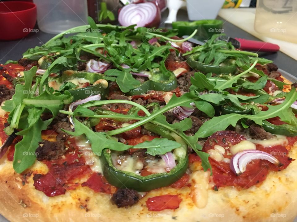 Pizza hot from the oven homemade topped with arugula 