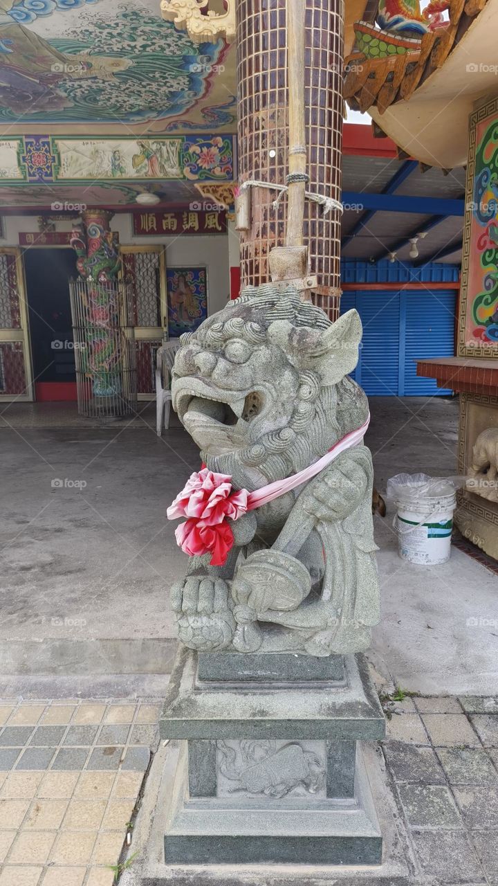 Statue of a lion at the entrance to the temple.
