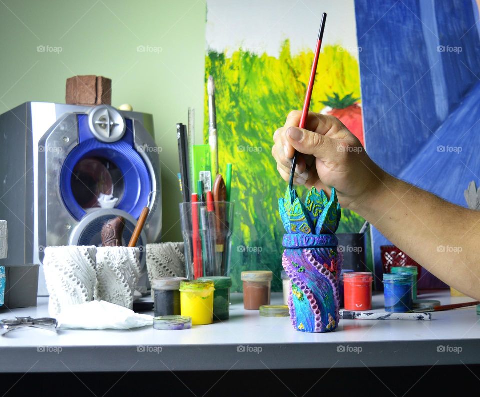 my home workshop for pouring and painting ceramic and earthenware jugs. The photo shows a jug being painted with acrylic.