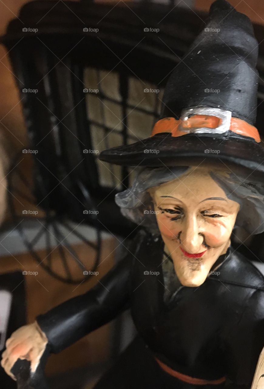 Creepy witch statue in front of a haunted carriage 
