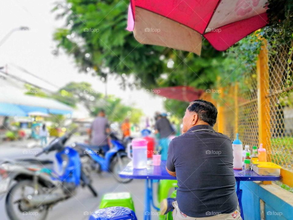 A man wait for food in the street food restaursnt