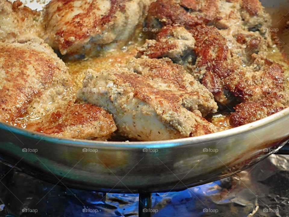 Closeup of chicken cooking in pan