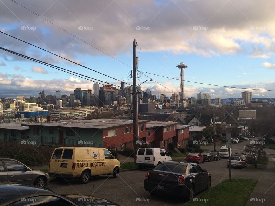 Seattle skyline and space needle seen from a city street with cable wires above