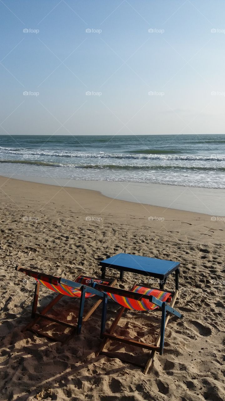 Two chairs with table on the beach