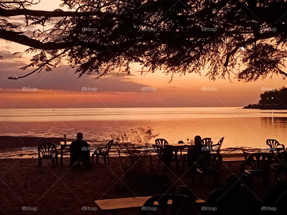 Beautiful sunset by the beach,  restaurant in the sand