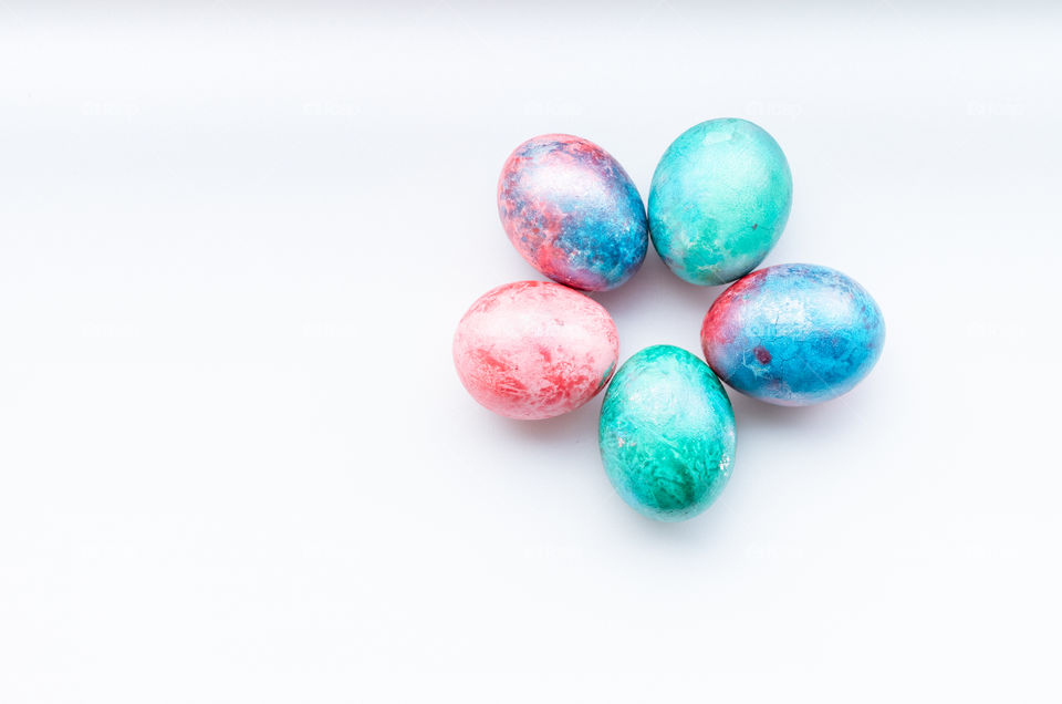 Top view of colourful dyed Easter eggs on a white background.