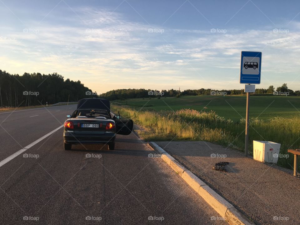 Broken moody green convertible in a sunset