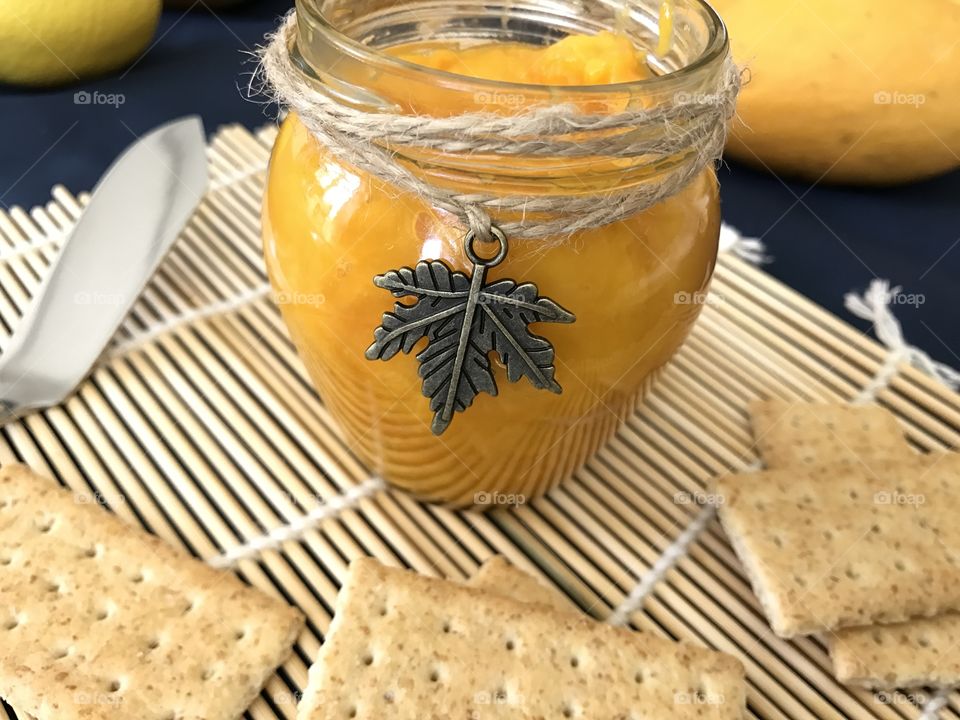 Mango jam with crackers on bamboo plate mat