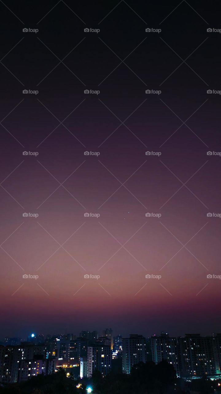 The photo depicts a mesmerizing celestial event - the conjunction of Venus and Jupiter in the night sky. The two planets, often referred to as "wandering stars" in ancient times, appear as bright dots of light, almost perfectly aligned in the center