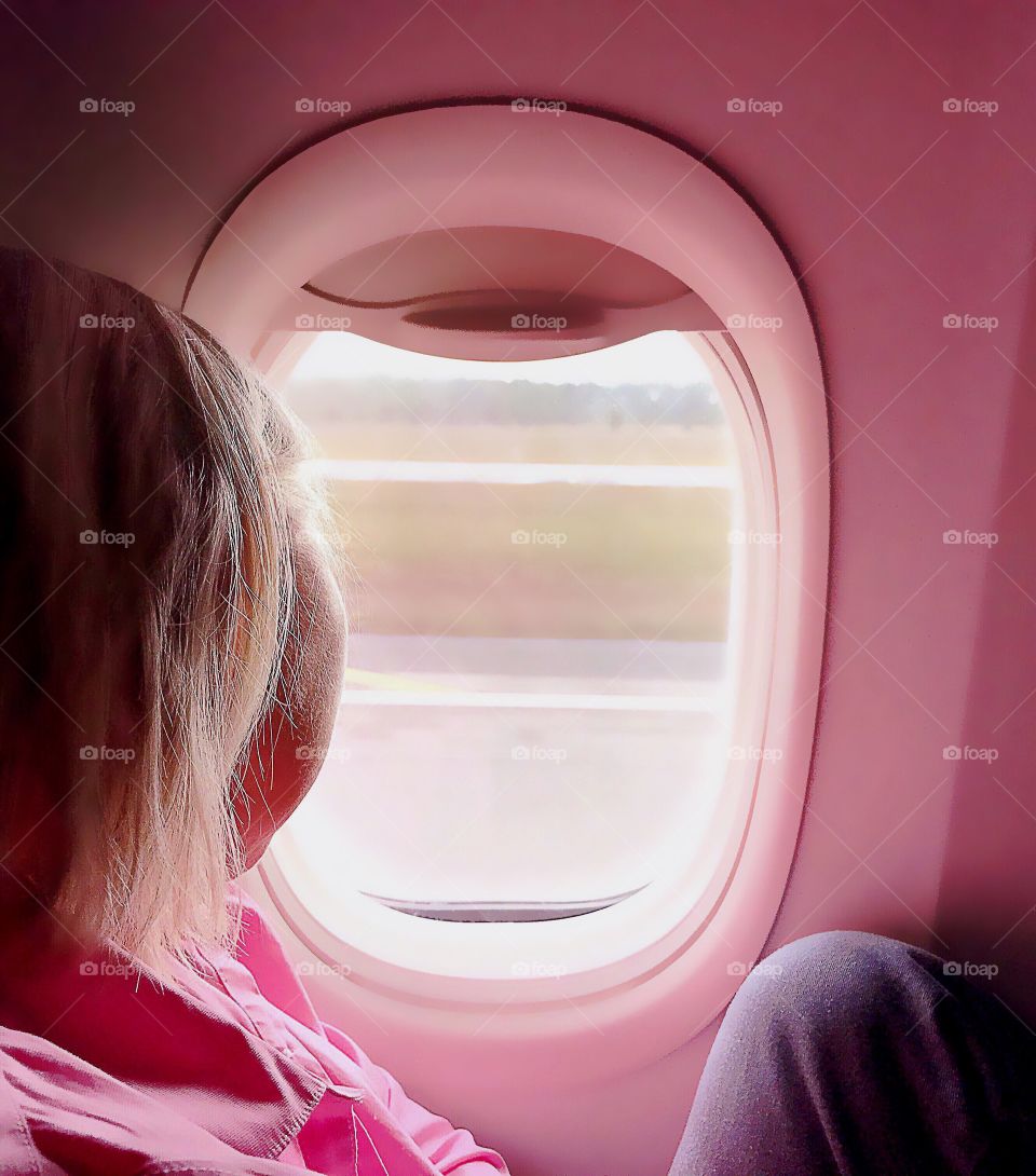 Woman gazing out an airplane window.