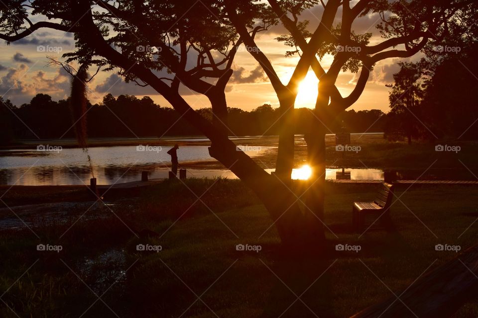 An older man enjoys a days catch during a beautiful sunset the everglades of Florida.