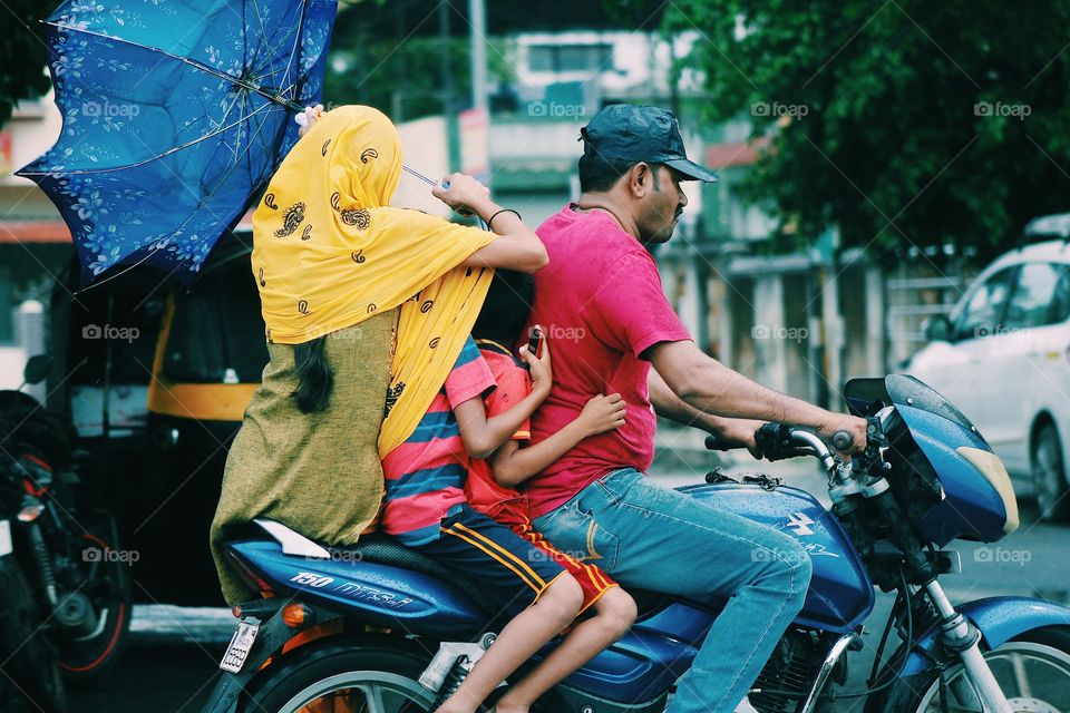 A family of four in the busy life's and monsoon rains of Mumbai india 