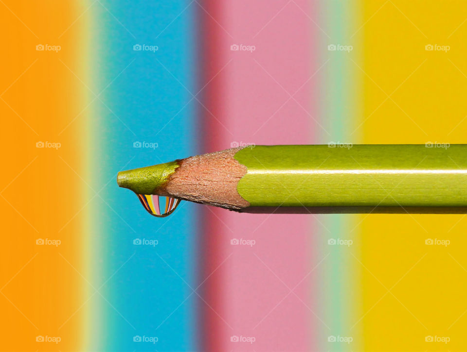 Colorful reflection in the water drop on the top of color pencil