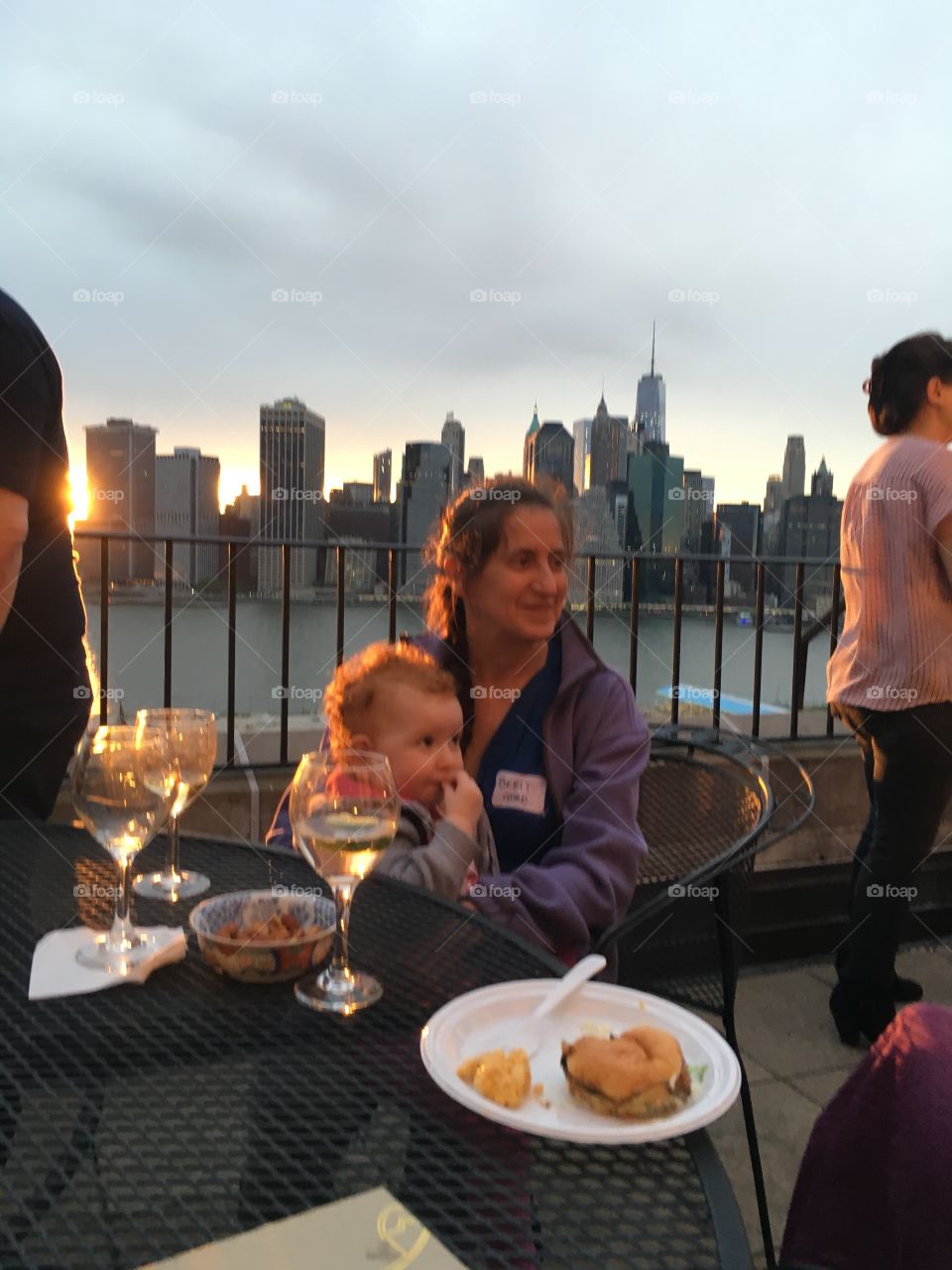 Dinner guests on the balcony of this luxury home on Pierrepoint Place in Brooklyn, NY. The Manhattan skyline is visible in the distance. 2017. Hypnotic Productions