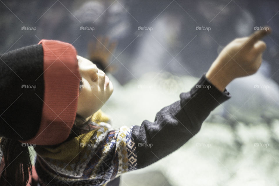 Japanese girl pointing at fish in aquarium