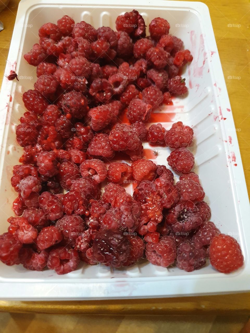 raspberries half eaten in the tray