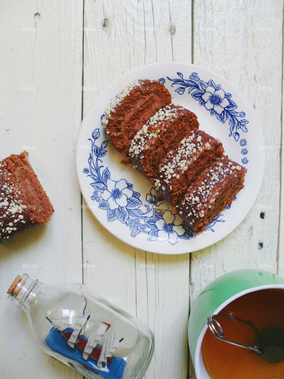 chocolate roll and a cup of black tea on a white background