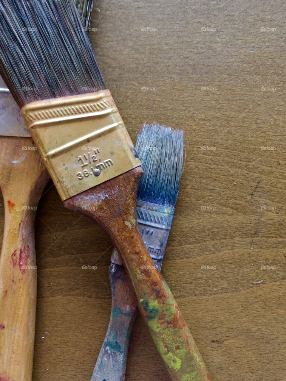 Used paintbrushes on wooden drafting table 