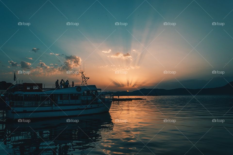 Scenic view of boat on sea at sunset