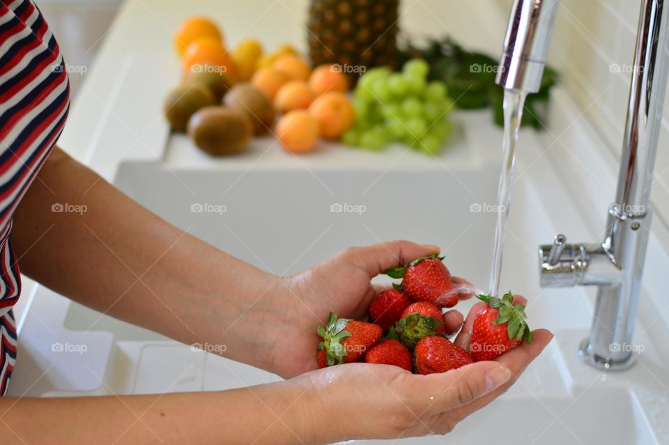 woman washing strawberries in the kitchen