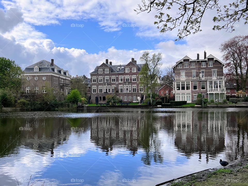 Old style residential buildings at the river canal bank with reflection in the smooth calm water 