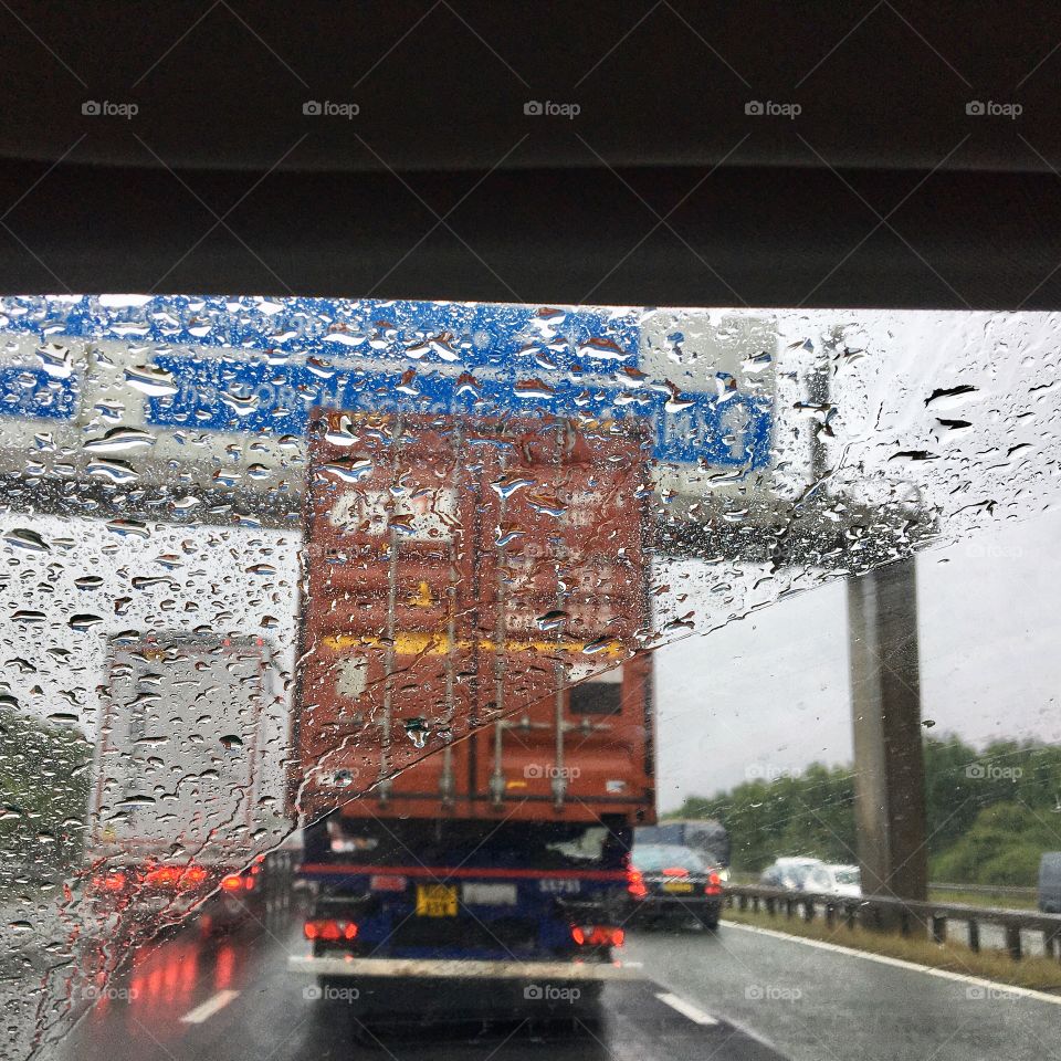 Window screen view of heavy rain whilst crawling along in a traffic jam on the motorway …