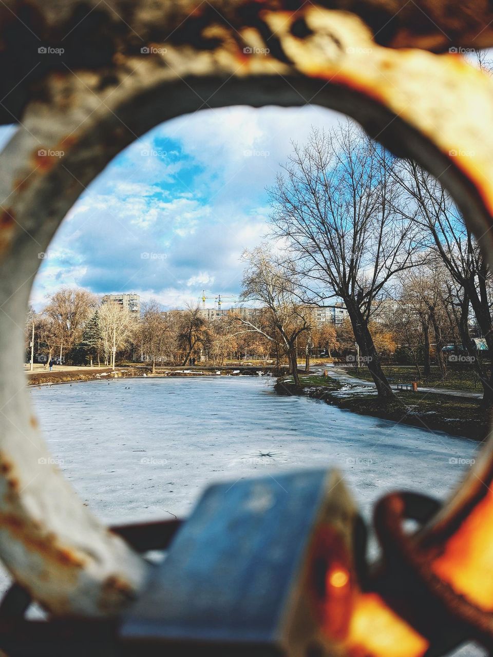 Round part of the old iron bridge over the river in the park. Winter landscape.