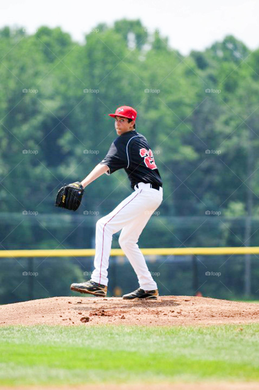 wind up on the mound. young pitcher winds up to throw off the mound
