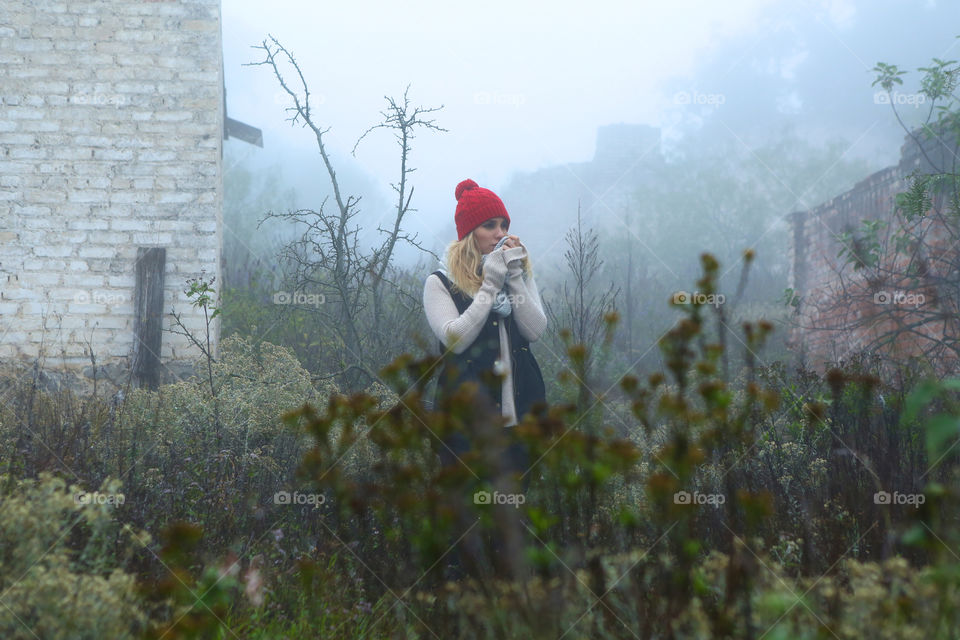 Blonde woman in warm clothes during foggy morning