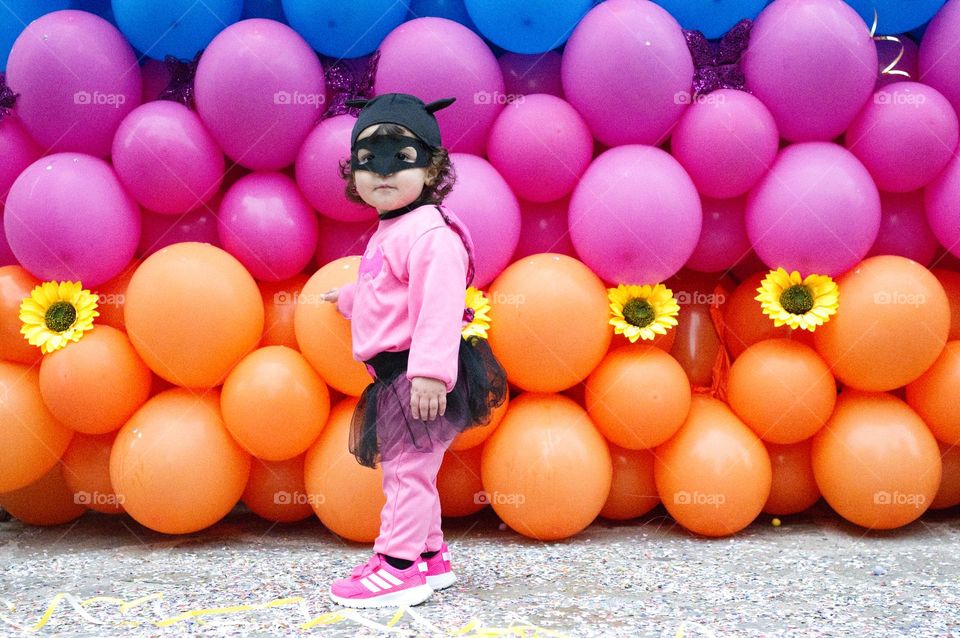 Bat girl surrounded by colorful balloons