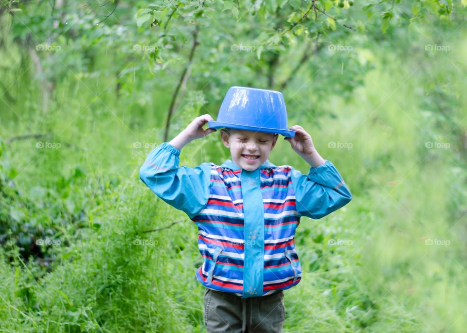 Children Playing in Rainy Spring Day with Buckets on Their Heads