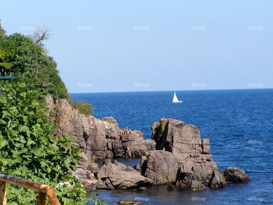 Sailing boat in the sea and rocks