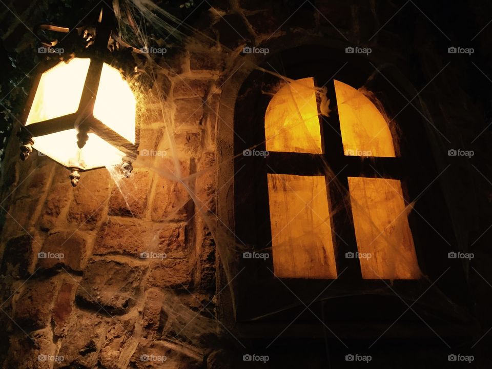 Spooky window with lamp and spider web