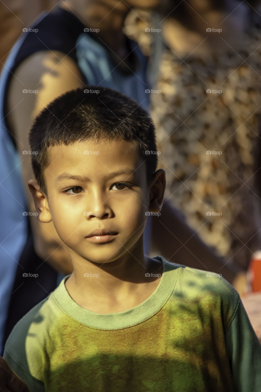 Portrait Asian boy standing looking background blur people.