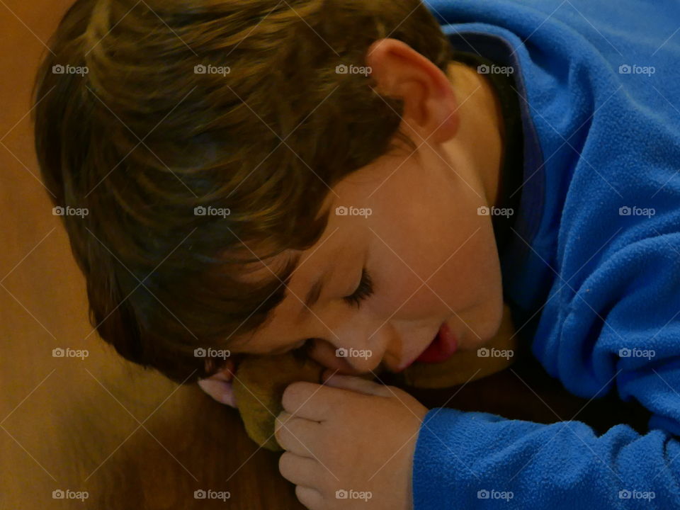 Close-up of a boy resting his head on table