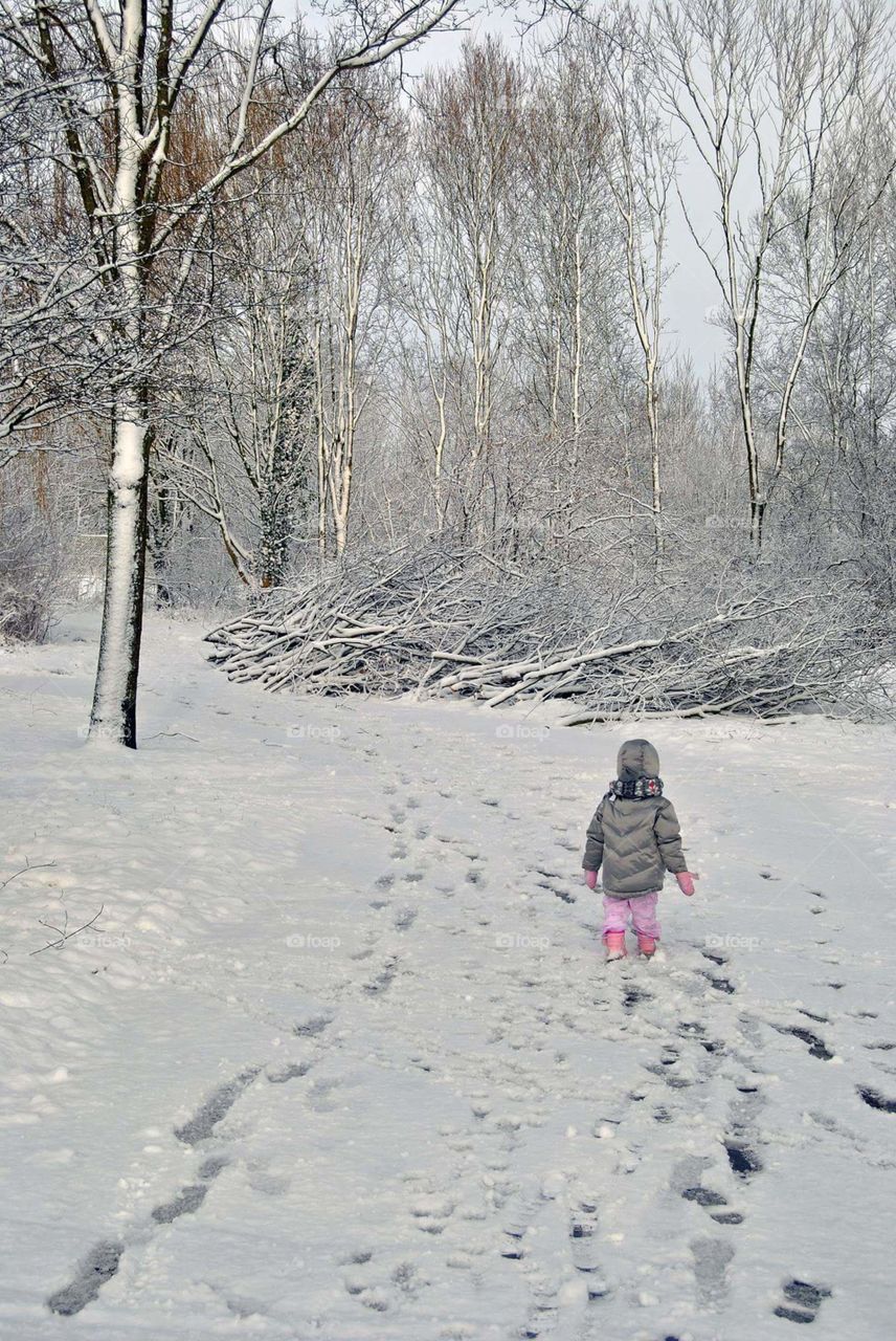 little girl walking in snow landscape