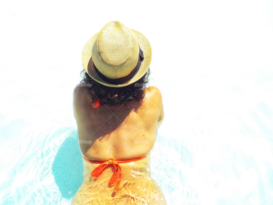 Woman from behind relaxes in the pool