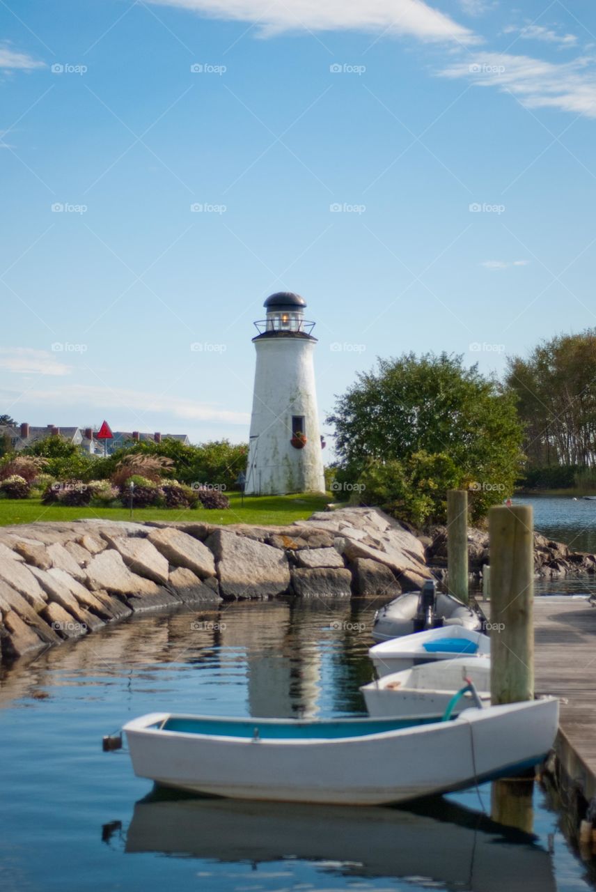 Lighthouse on Rocky Shore with Dinghy Boats in Kennebunkport Maine